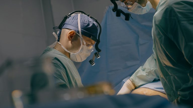 Team of men surgeons paramedics doctors operate patient laparoscopic gastric surgery operation on