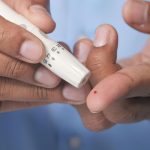 Persona realizando una punción en el dedo para medir la glucosa en sangre